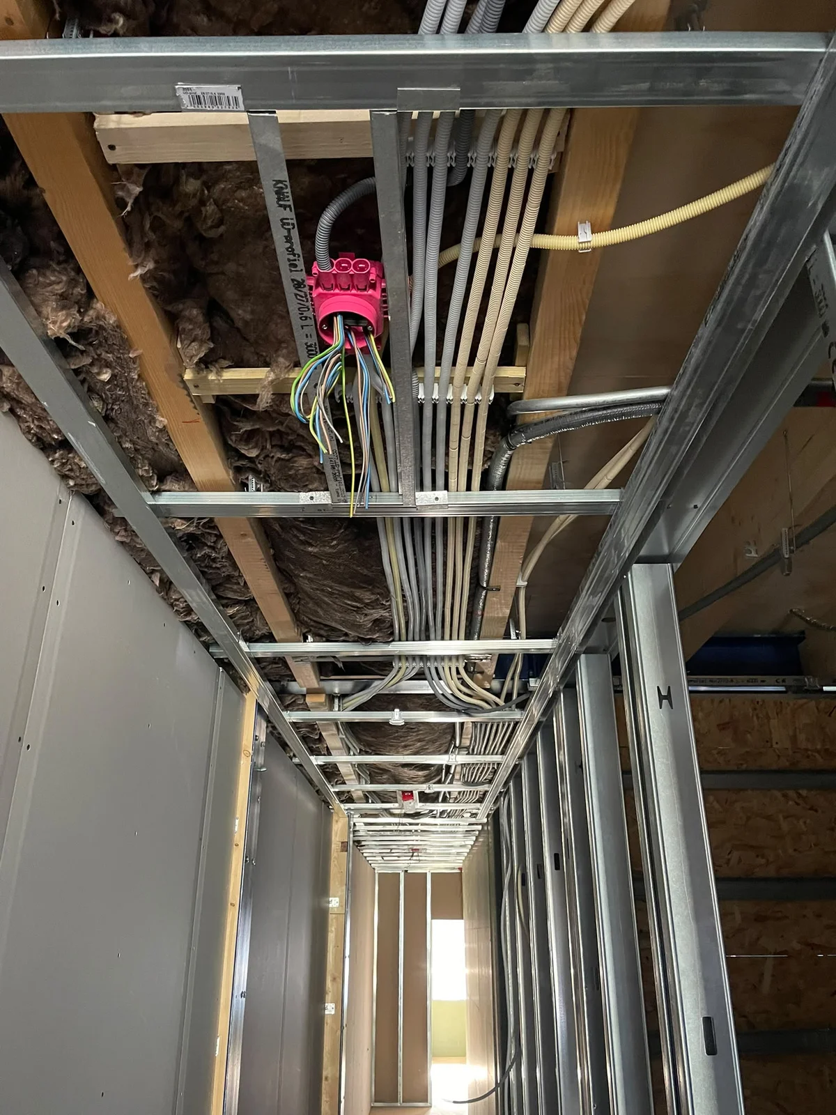 Detail van elektrotechnische voorzieningen boven een metalstudplafond