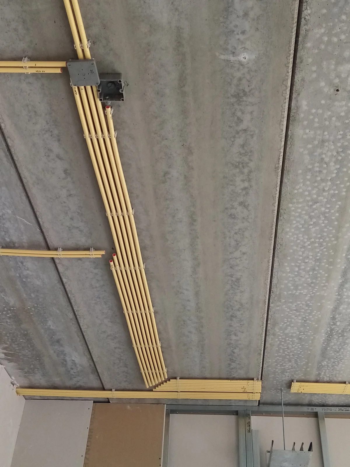 Leidingwerk en elektrische inbouwdozen in een betonnen plafond