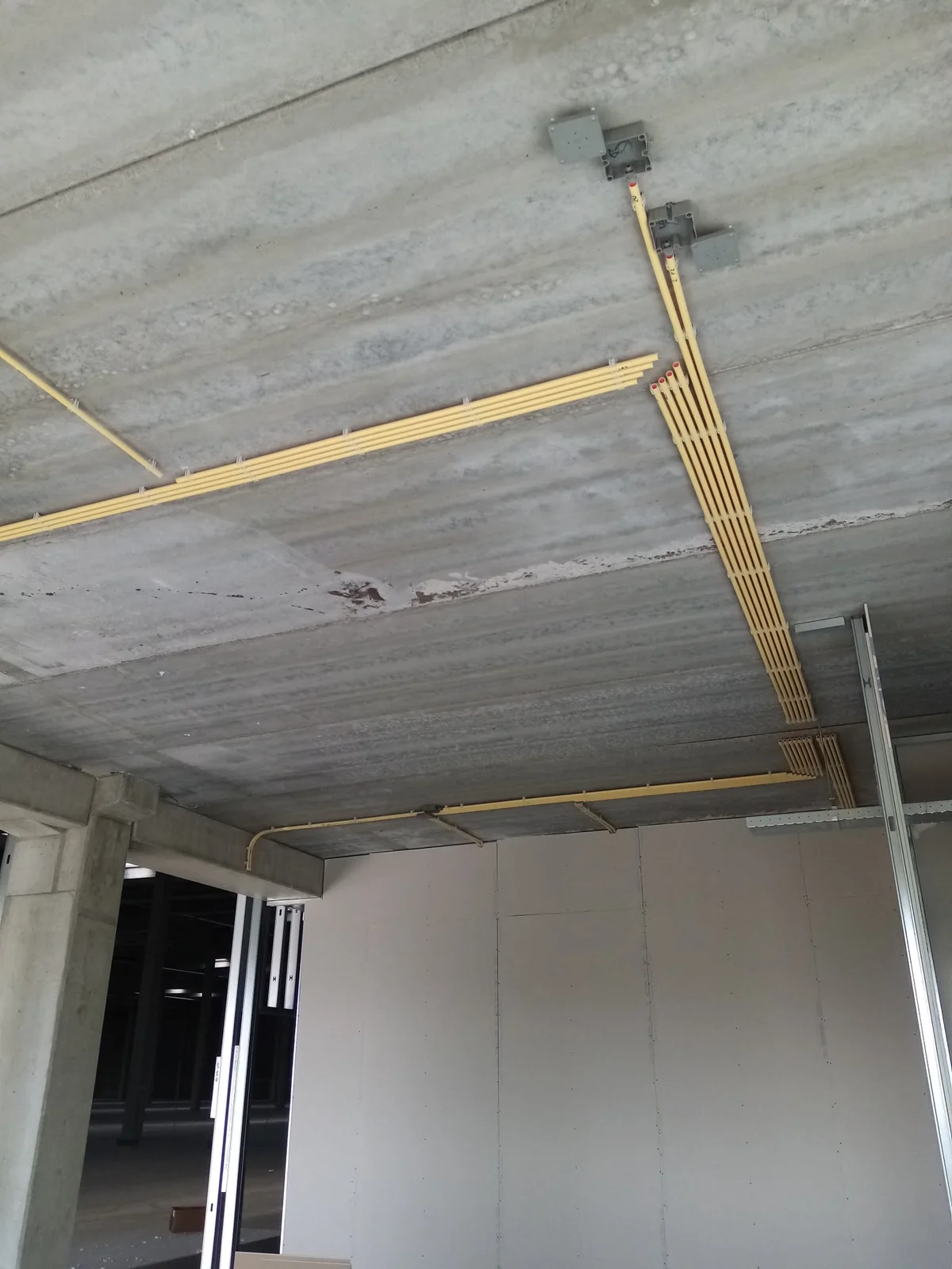 PVC-leidingwerk dat aansluit op een metalstudwand